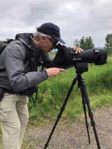 Ken Pitts looks through a spotting scope