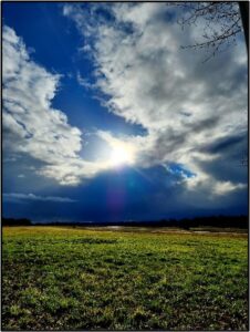 Sun shining through winter clouds by Susan Setterberg